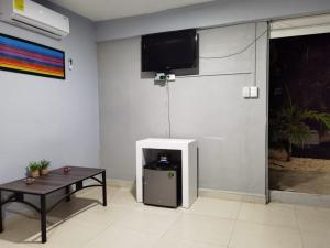 Una habitación con una mesa y un televisor en una pared. en Casa Buba, en Cozumel