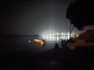 a boat sitting in the water at night at Apartments Ljiljana in Klek