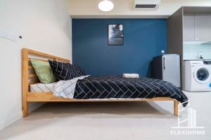 a bed in a room with a blue wall at 9am-5pm, SAME DAY CHECK IN AND CHECK OUT, Work from Home, Comfy & Quiet Tamarind Suites-Cyberjaya by Flexihome-MY, in Cyberjaya