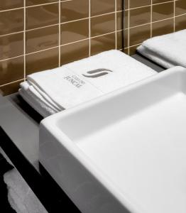 dos toallas blancas están sentadas en un mostrador en un baño en Casa do Juncal en Guimarães