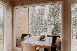 a dining room with a table and chairs and a large window at Villa Varis in Jorvas