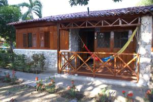 ein Haus mit einer Holztür und einer Veranda in der Unterkunft Chalet Condominio Campestre Rodadero Santa Marta wifi Piscina Amplia in Santa Marta