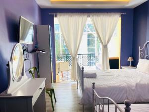 a bedroom with a bed and a balcony at Jardin De Mangue Pakchong in Pak Chong
