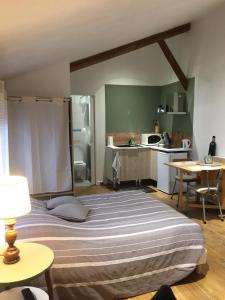 une chambre avec un grand lit et une cuisine dans l'établissement La Bulle, à Châlons-en-Champagne