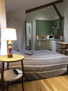 um quarto com uma cama e uma mesa com um candeeiro em La Bulle em Châlons-en-Champagne