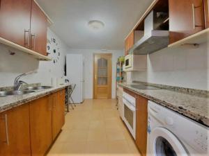 a kitchen with a sink and a washer and dryer at Apartamento Coliseo Almuñecar in Almuñécar