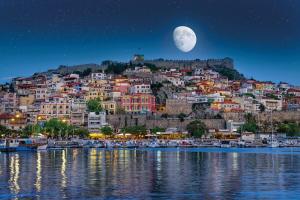une ville sur une colline avec la lune dans le ciel dans l'établissement HOLIDAY KAVALA, à Kavala