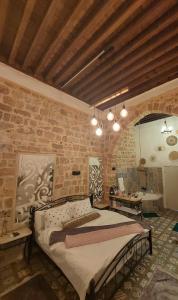 a bedroom with a large bed in a brick wall at تاج عكا Taj Akko in &lsquo;Akko