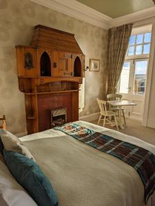 a bedroom with a bed with a fireplace and a table at Furain in Peterculter