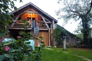 Cabaña de madera con balcón en un patio en Au-Gré Du Lot, en Le Bourg