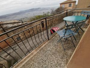 uma mesa azul e cadeira na varanda de uma casa em Uscio e bottega em Montepulciano