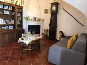 a living room with a couch and a grandfather clock at vivenda descollaz in Falcoeiras