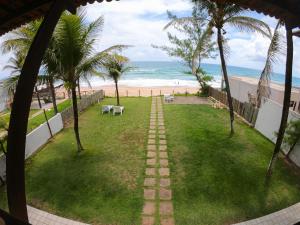 a pathway leading to a beach with palm trees at Porto Paraiso Hostel in Porto De Galinhas