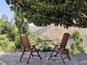 duas cadeiras e uma mesa debaixo de uma árvore em Casa Pappadiana Traditional stonehouse em Kefálion