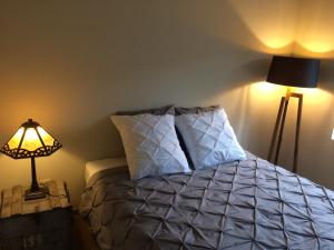 una camera da letto con un letto con una lampada e un cuscino di Gezellig stadshuisje met patio. a Tongeren