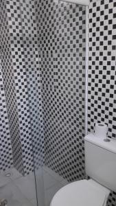 ein Bad mit schwarz-weiß gefliesten Wänden und einem WC in der Unterkunft Hotel Pousada Clínicas Jardins Paulista in São Paulo