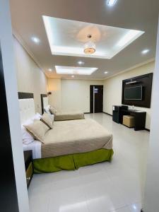 a bedroom with two beds and a flat screen tv at PALMAR CENTER in El Guabo