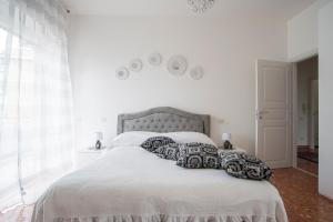 a white bedroom with a large bed with pillows at A Casa di Ale in Rome