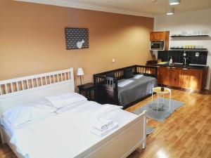 a bedroom with a white bed and a kitchen at Apartmány Margo Sun in Martinske Hole +33 photos
