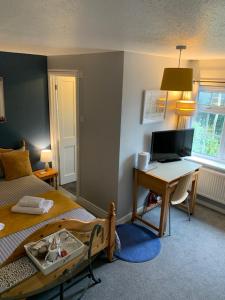 a bedroom with a bed and a desk with a computer at The Holly Tree in Cambridge