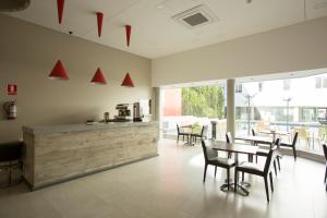a dining room with tables and chairs and a counter at Regency Way Montevideo Hotel in Montevideo