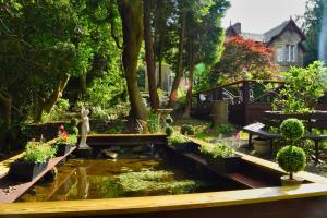塞爾柯克的住宿－希思樂利旅遊別墅酒店，花园,花园内有种有植物的池塘和桥梁