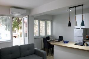 een keuken met een bank en een tafel in een kamer bij Spacious modern apartment Kisela Voda in Skopje