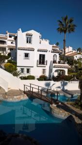 a white building with a bridge over a swimming pool at Villa an der Costa Blanca in Villacosta