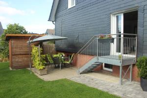 een patio met een tafel en een parasol bij Ferienwohnung Dellori in Winterberg