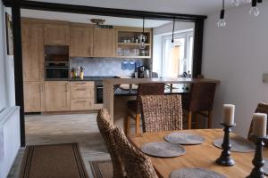 a kitchen with a wooden table and a dining room at Ursprüngliches Harzhaus für Aktive in Clausthal in Clausthal-Zellerfeld