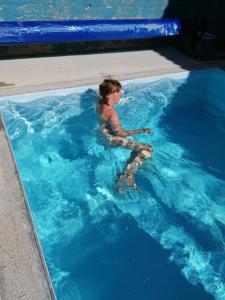 un niño pequeño sentado en una piscina en Au Domaine de Sophie piscine chauffée couverte et jacuzzi couvert, en Crasville