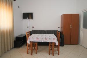 a table and chairs with a table and a couch at Vila Agushi in Ksamil