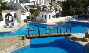 a bridge over a pool with blue water at Villa an der Costa Blanca in Villacosta