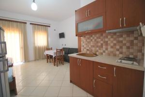 a kitchen and a living room with a table at Vila Agushi in Ksamil