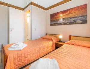 une chambre avec deux lits et un tableau au mur dans l'établissement Casa Helen, à SantʼAntìoco