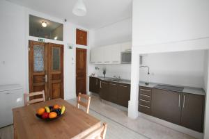a kitchen with a table with a bowl of fruit on it at Alojamento Local Primavera in Amadora +16 photos