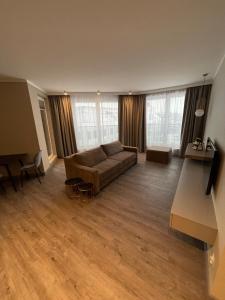 a large living room with a couch and some windows at Bell Mare 418 Maris 60m2 in Międzyzdroje