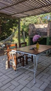 una mesa de madera y un banco en un patio en El Dormilon 2, en La Pedrera