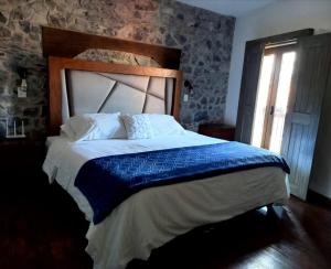 a bedroom with a large bed with a wooden headboard at Hotel Canaria in Santeagueda