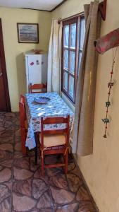 mesa y sillas en una habitación con ventana en El Dormilon 2, en La Pedrera