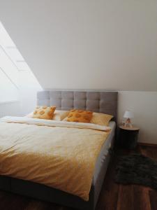 sypialnia z dużym łóżkiem z żółtymi poduszkami w obiekcie Apartmán pri parku w mieście Seredʼ