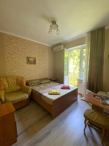 ラザレフスコエにあるPrimorskaya Mini Hotelのベッドルーム1室(ベッド1台、ソファ、テーブル付)