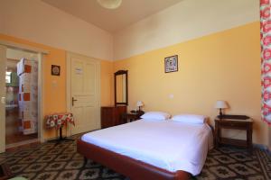 a bedroom with a large white bed and yellow walls at Hotel Anastasia in Rhodes Town