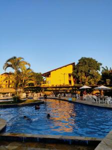 a swimming pool with people in the water at Flat WinterVille Residence - Gravatá in Gravatá +23 photos
