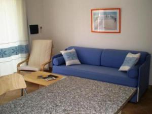 a living room with a blue couch and a table at Residence Floreal in San Pasquale
