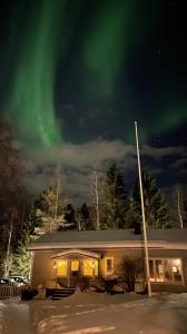 a house with the aurora in the sky at Arctic Circle Tranquillity in Rovaniemi