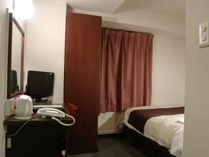 Habitación de hotel con cama y escritorio con teléfono en Hamamatsu Station Hotel - Vacation STAY 65843, en Hamamatsu
