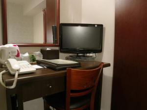 escritorio con monitor de ordenador y teléfono en Hamamatsu Station Hotel - Vacation STAY 65843, en Hamamatsu