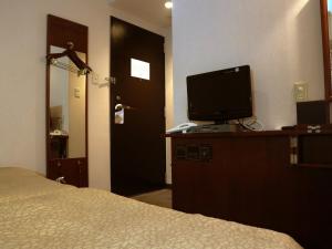 a bedroom with a bed and a television on a dresser at Hamamatsu Station Hotel - Vacation STAY 65834 in Hamamatsu