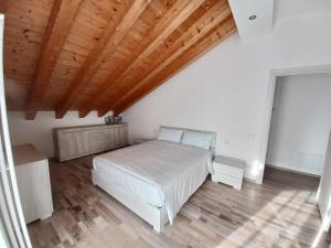 een slaapkamer met een wit bed en een houten plafond bij Casa Luna in Pieve di Cadore